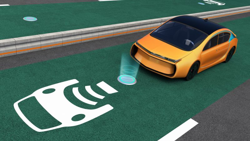 Yellow electric car on EV wireless charging lane.